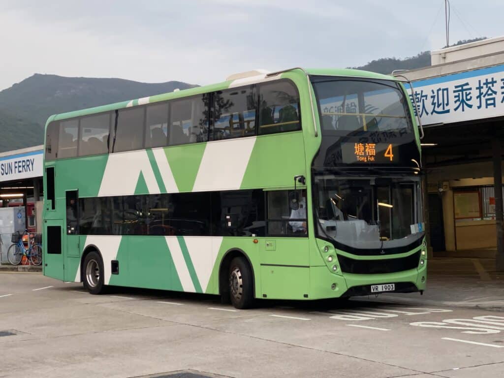 Green and white double-decker bus parked at a Hong Kong terminal, displaying route number 4 to Tong Fuk with Chinese characters on the destination display.