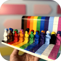 Colorful LEGO minifigures arranged by rainbow hue on a transparent shelf, displaying organized toy collection with vibrant primary and secondary colors.