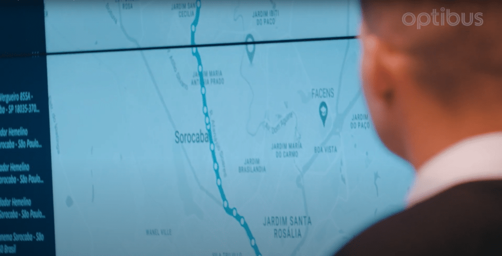 A person views a digital map on screen displaying Sorocaba and surrounding neighborhoods in São Paulo, Brazil, with a blue transit route marked prominently.