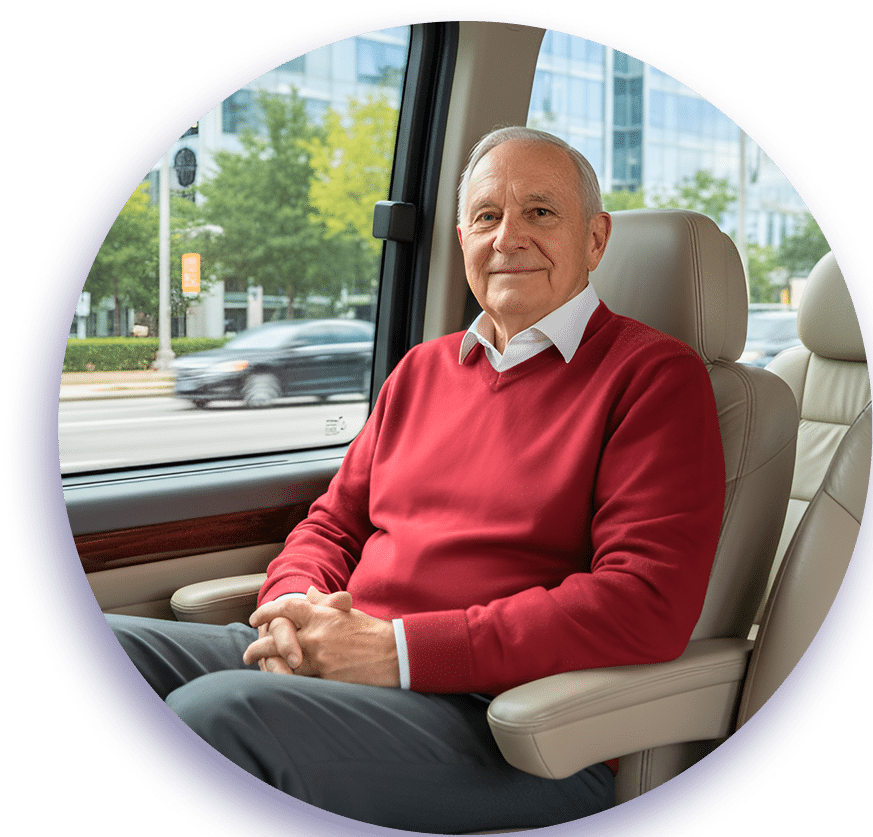 Senior man in red sweater seated in luxury car interior with urban street view through window, presenting professional and confident appearance.