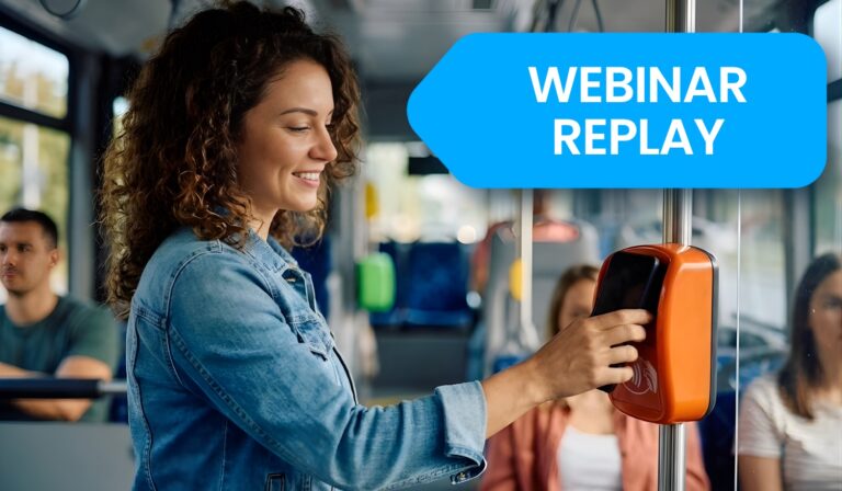 Woman on public transit holds smartphone to orange contactless payment reader while smiling, demonstrating mobile payment technology in everyday commuting scenario.