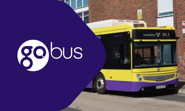 Go Bus branded yellow and purple bus with route 88.3 displayed, parked outside a brick building in the UK with visible registration plate BV20 CPO.
