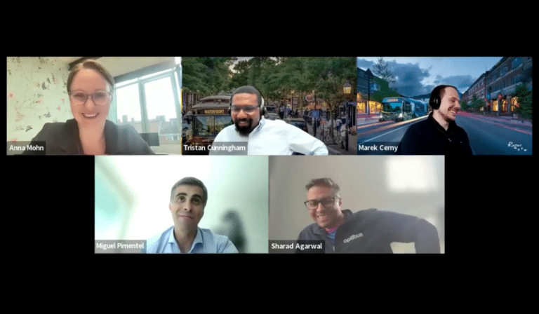 Five professionals participate in a virtual video conference call, each displayed in separate screen tiles showing their names and backgrounds during an online meeting.