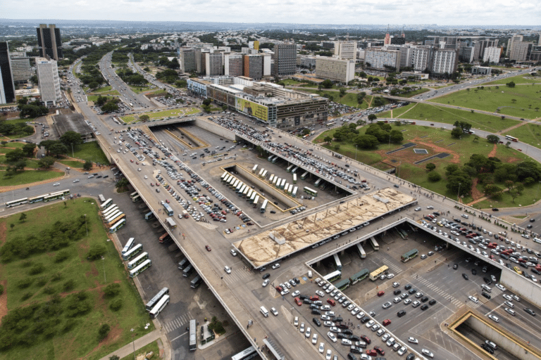 Aerial view of a major Brazilian shopping center and transportation hub with extensive multi-level parking, bus terminals, and surrounding high-rise buildings in an urban metropolitan area.