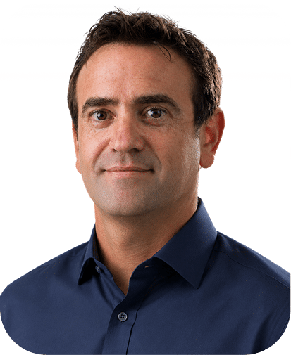 Professional headshot of a middle-aged man wearing a dark blue button-up shirt against a white background, displaying a confident neutral expression.